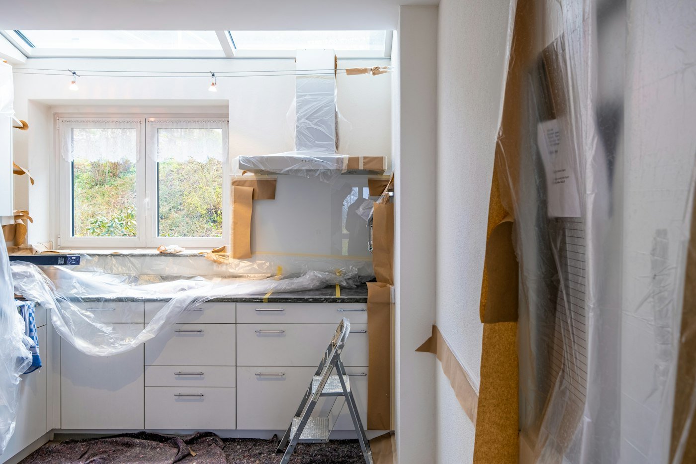 Kitchen being fitted with floors protected during renovation